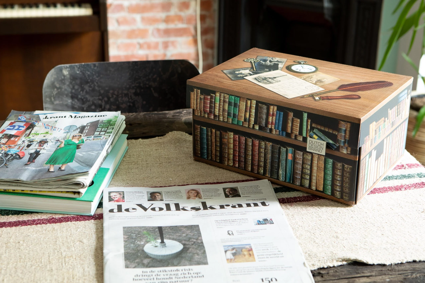 Två förvaringslådor i kartong med tryck av böcker. Inspirationsbild med tidning