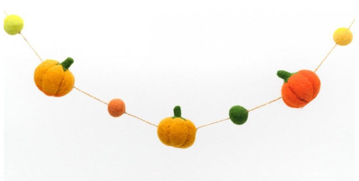 Handgjord girlang med filtade pumpor i olika orange färger 