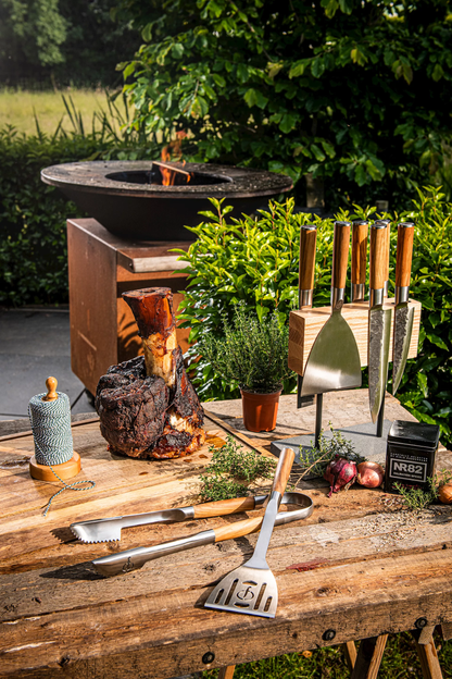 Alla bbq vertygen från forged på ett bord utomhus vid en grill.