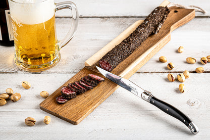 Korvskärbräda med kniv. Akacia. Svart Laguiolekniv. Inspirationsbild med korv 